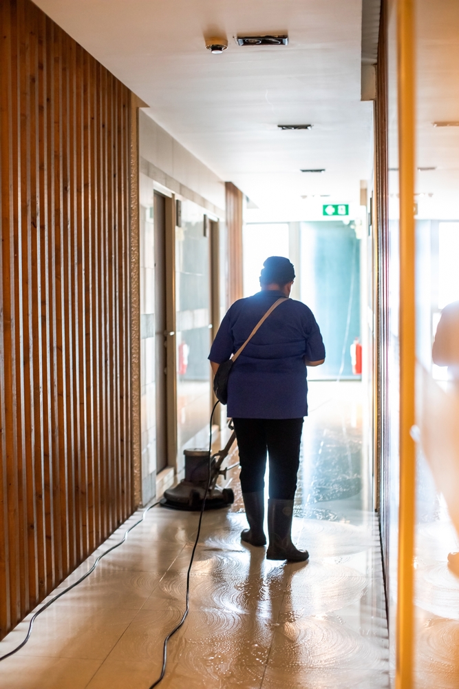 woman,worker,cleaning,the,floor,with,polishing,machine,in,condominium